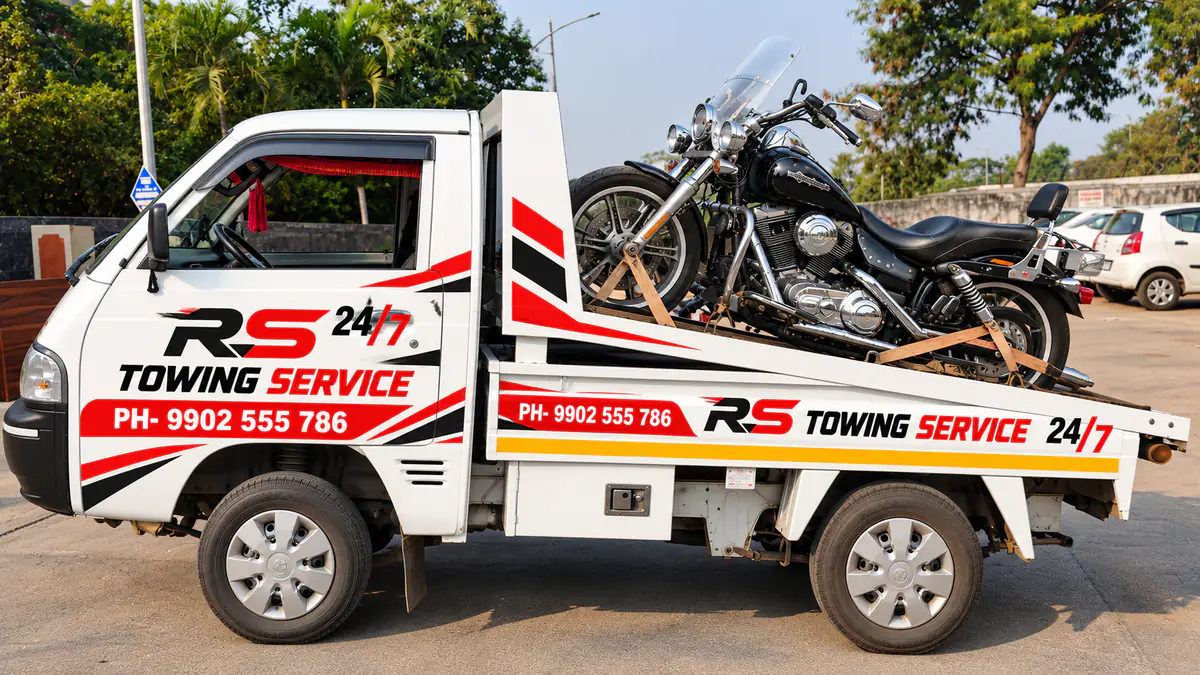 RS Towing Service pickup truck with a black cruiser motorcycle strapped on the back in Bangalore