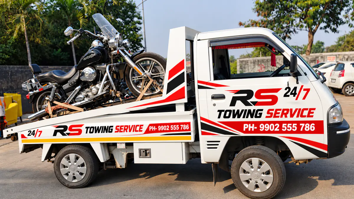 White RS Towing Service pickup truck carrying a black cruiser motorcycle on its loading deck, on duty for our 24/7 towing service in Bangalore
